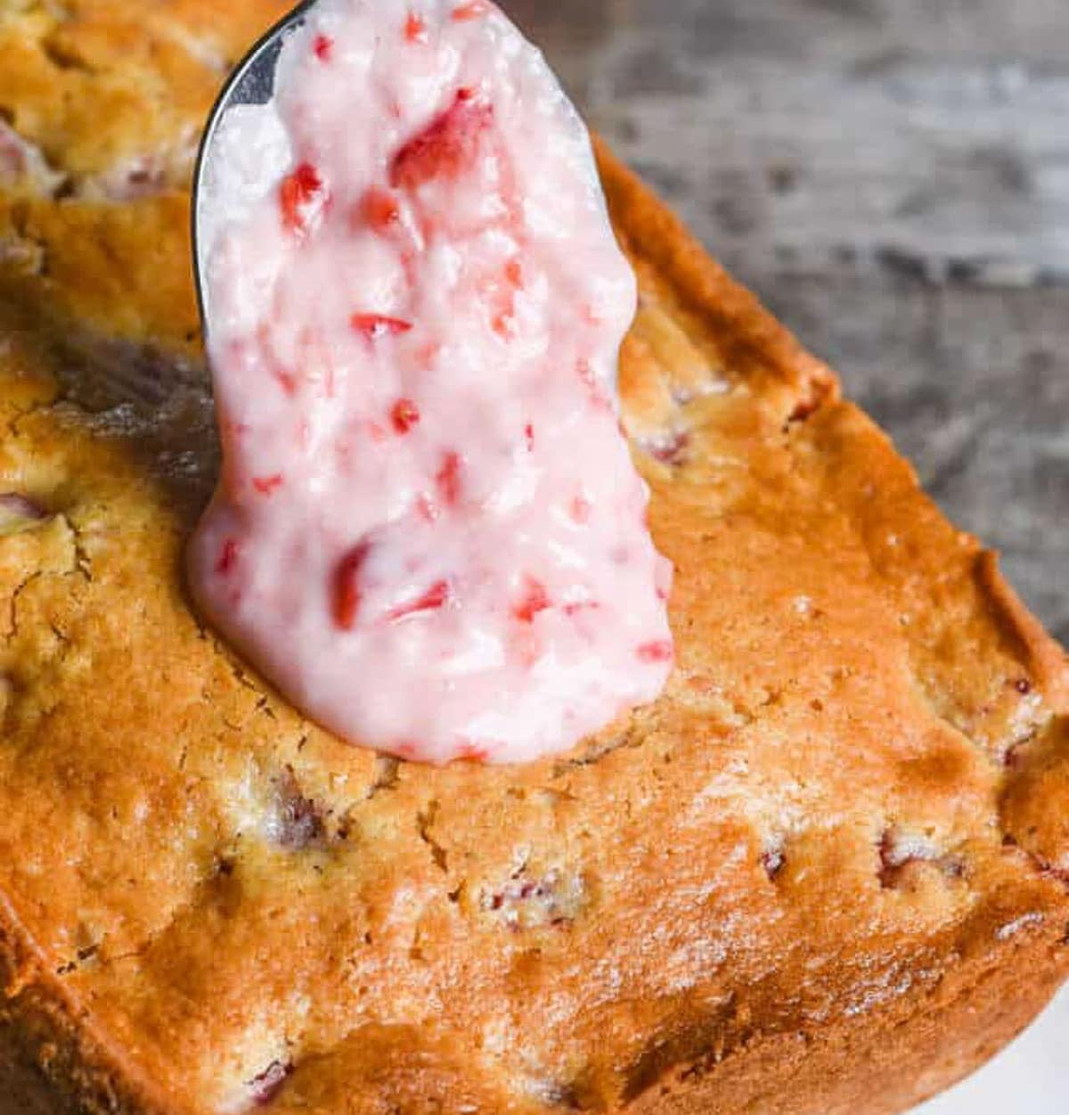 spooning glaze over bread with strawberries