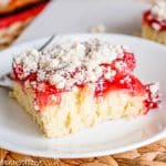 A piece of cake on a plate, with Cherries