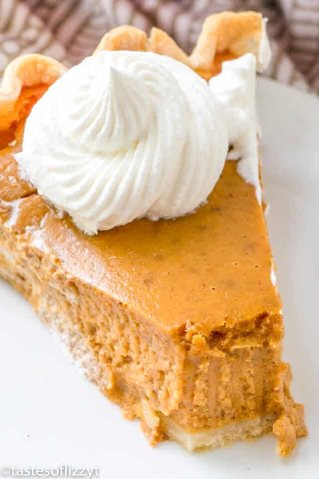 slice of the best pumpkin pie topped with a dollop of whipped cream