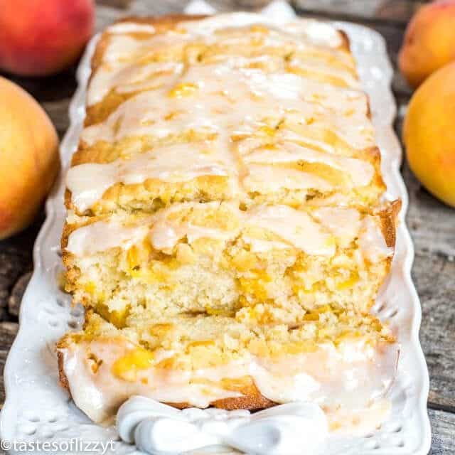 peach bread with glaze sliced on a white platter