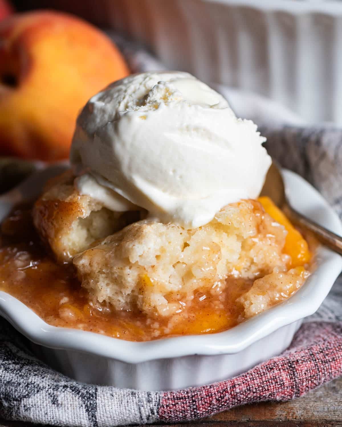 peach cobbler in a bowl with ice cream on top