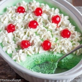 green jello salad with whipped cream and cherries