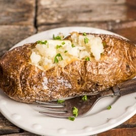 baked potato on a plate with a fork