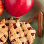 pile of mini apple pies with apple and cinnamon stick