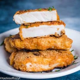 fried pork chops on a plate, one cut in half