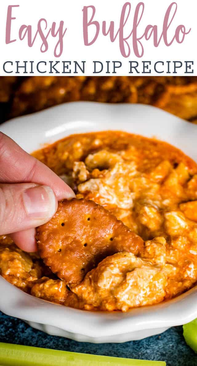 hand holding cracker in buffalo chicken dip