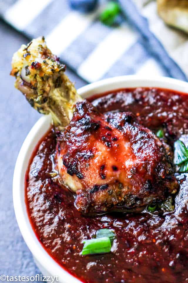 chicken wing dipping in blueberry sauce