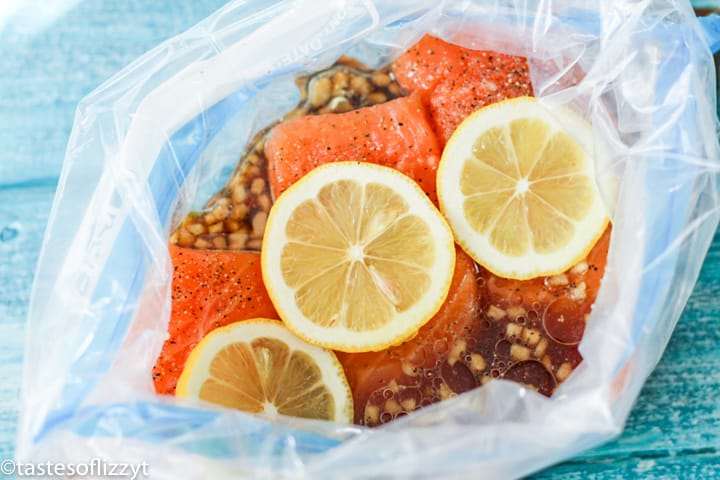 salmon fillets marinating with lemons in plastic bag
