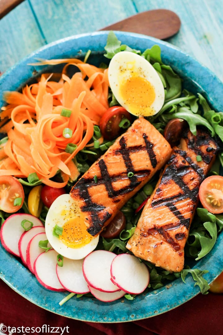 A plate of food on a table, with Salmon and salad