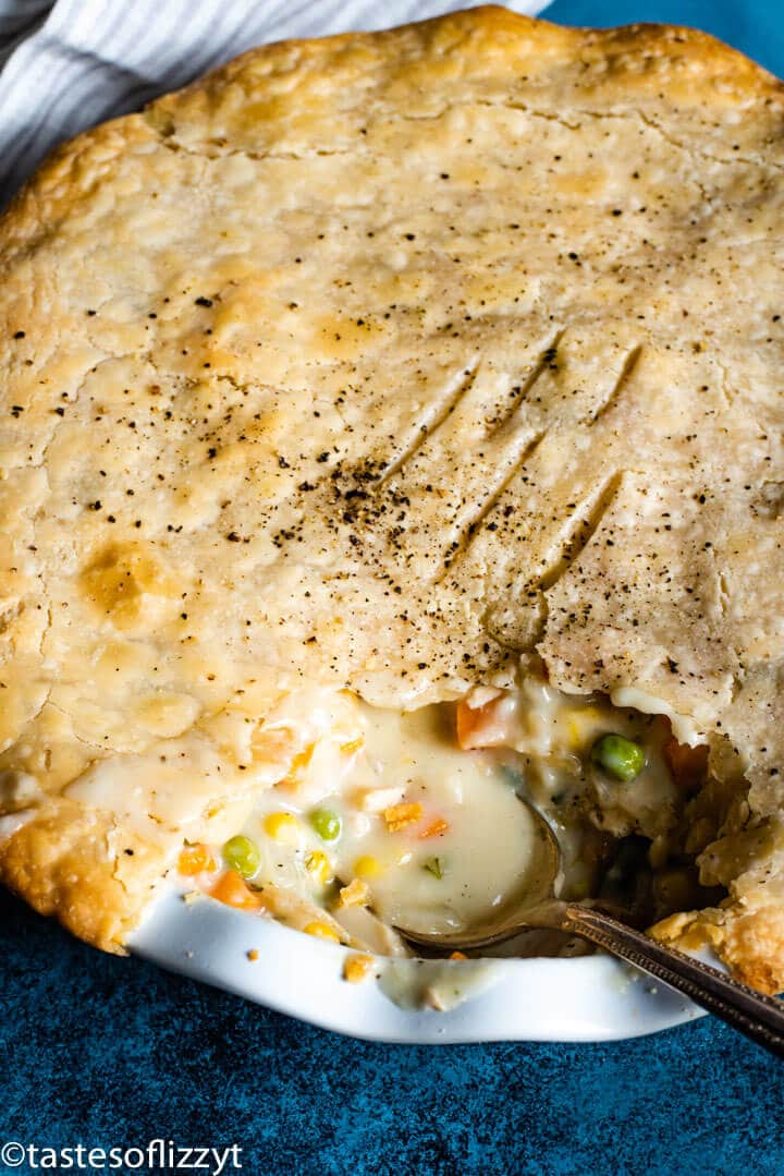A close up of a chicken pot pie with spoonful out