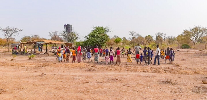 A group of people walking down a dirt road