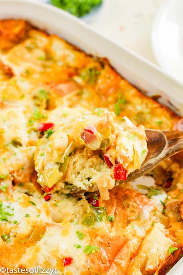 A close up of egg casserole on a wooden spoon