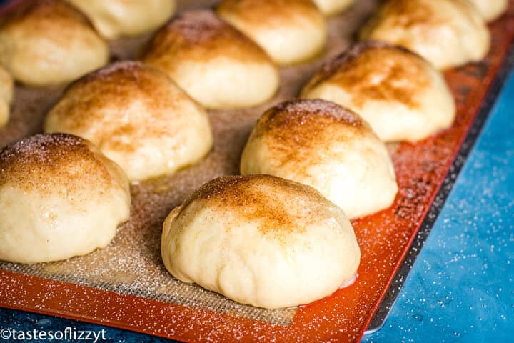 A close up of a pan of unbaked rolls