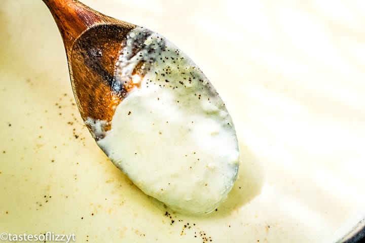 alfredo sauce on a wooden spoon