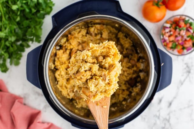 instant pot salsa verde chicken and rice on a wooden spoon