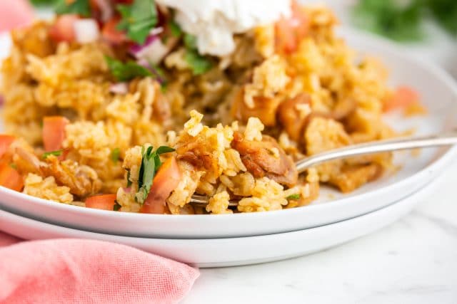 chicken and rice on a plate with a fork