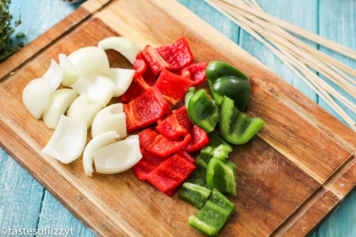 peppers and onions on a wooden cutting board