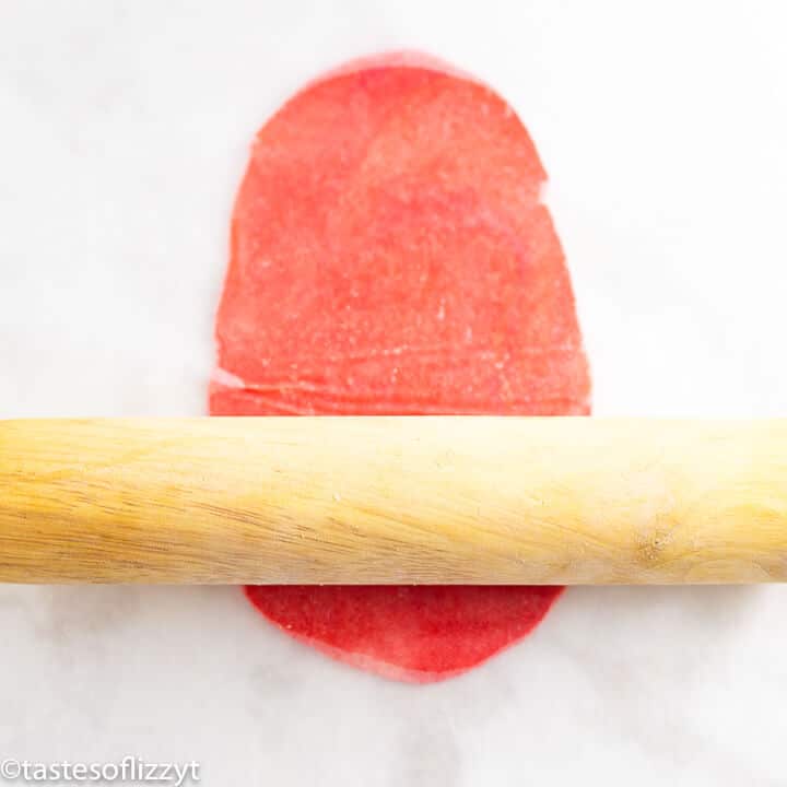 rolling out red cookie dough