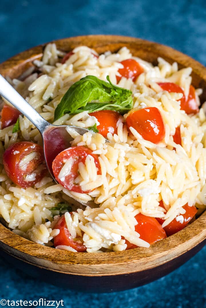 A bowl of food, with tomatoes and Orzo