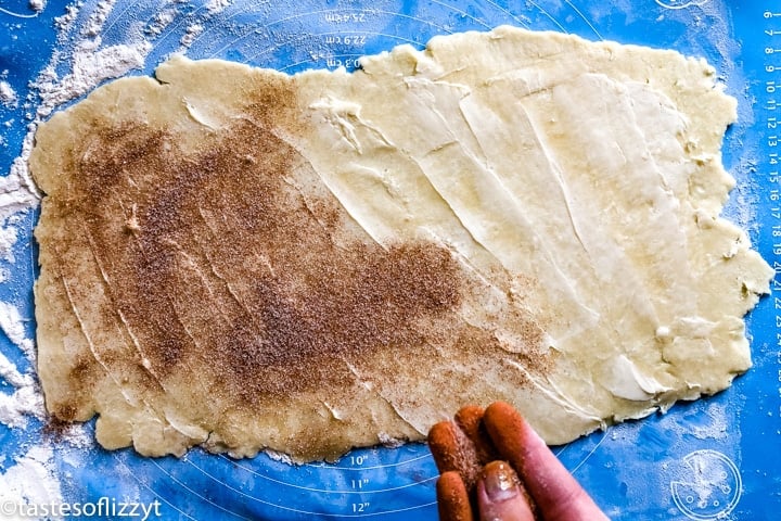 sprinkling cinnamon and sugar on pie crust