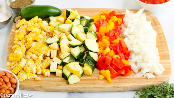 A bunch of food is on a cutting board, with Summer squash