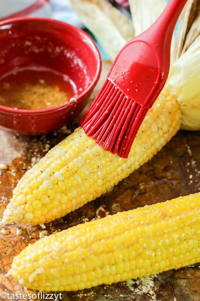 brushing butter on corn on the cob