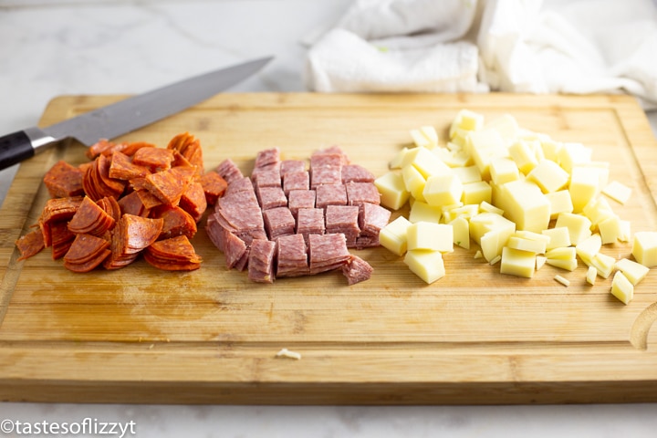 diced pepperoni, salami and cheese on a cutting board