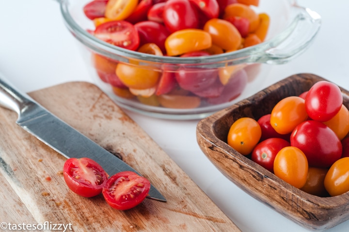 A bowl of tomatoes sitting on top of a wooden table