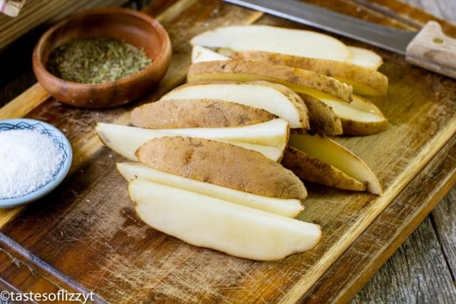 cut potato wedges on a cutting board