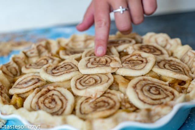 placing cinnamon rolls on top of a pie