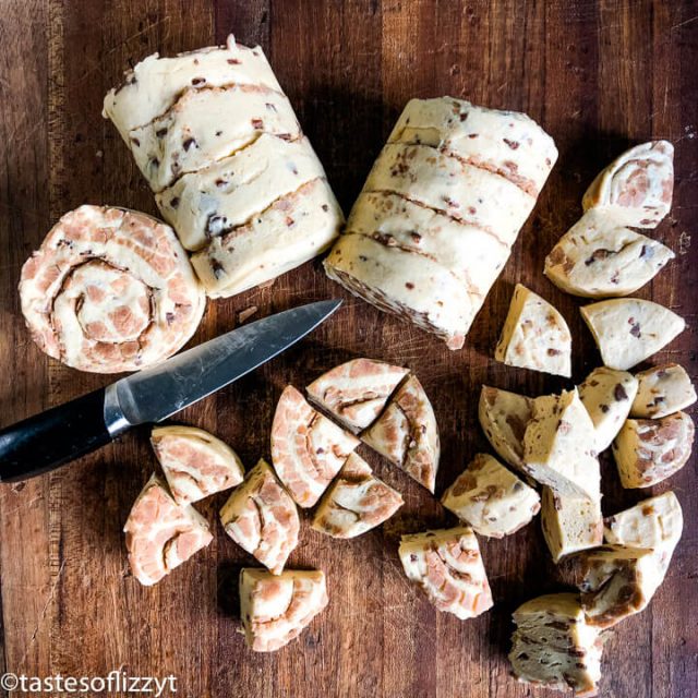 cinnamon rolls quartered on cutting board
