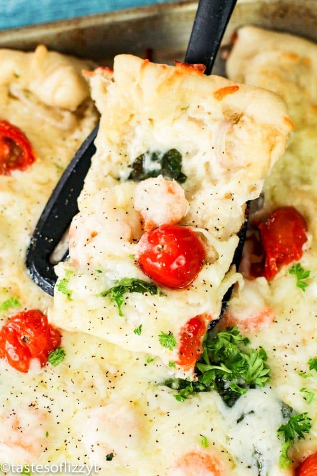 slice of shrimp alfredo pizza on a spatula