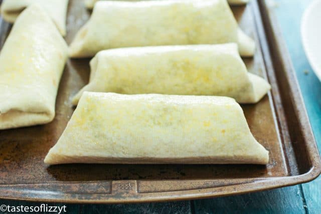 rolled tortillas on wooden cutting board