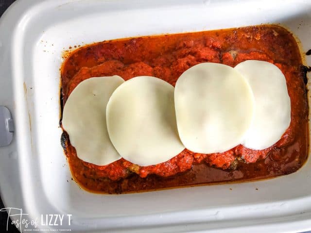 cube steaks in a slow cooker with sauce and cheese