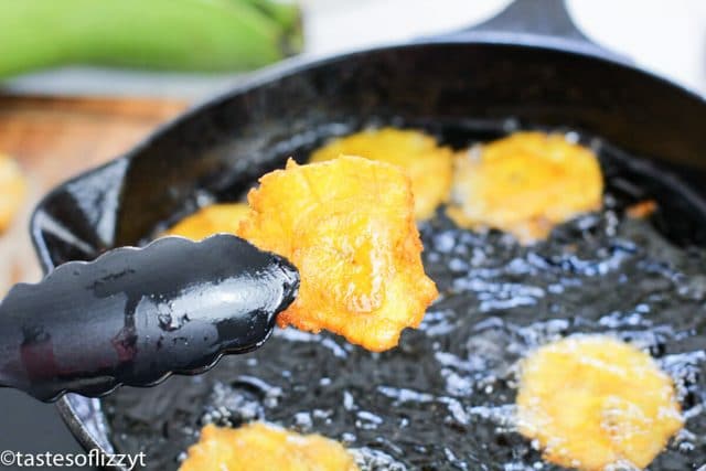 tongs holding fried plantain