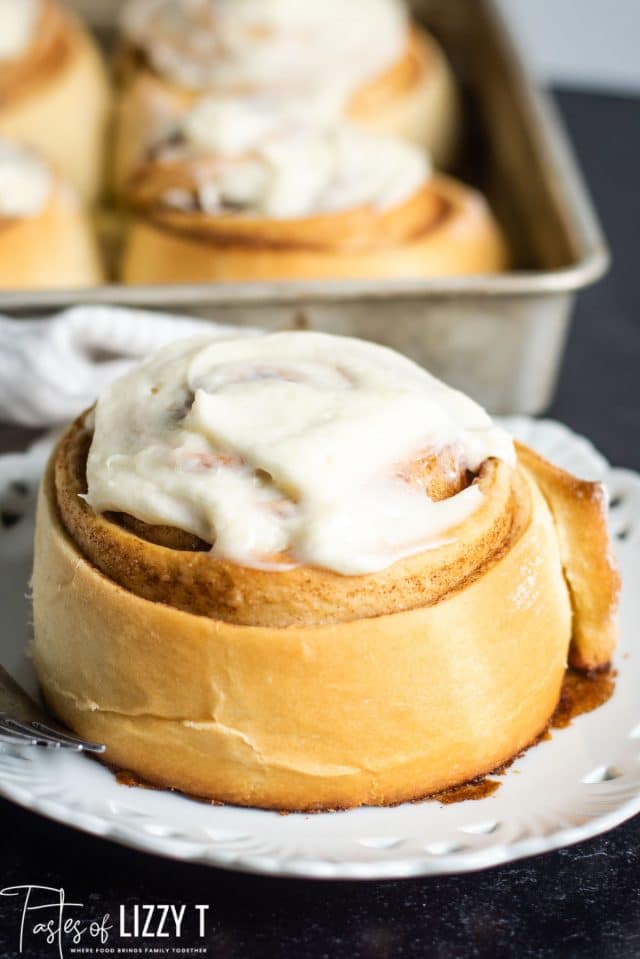 large frosted cinnamon roll on a plate