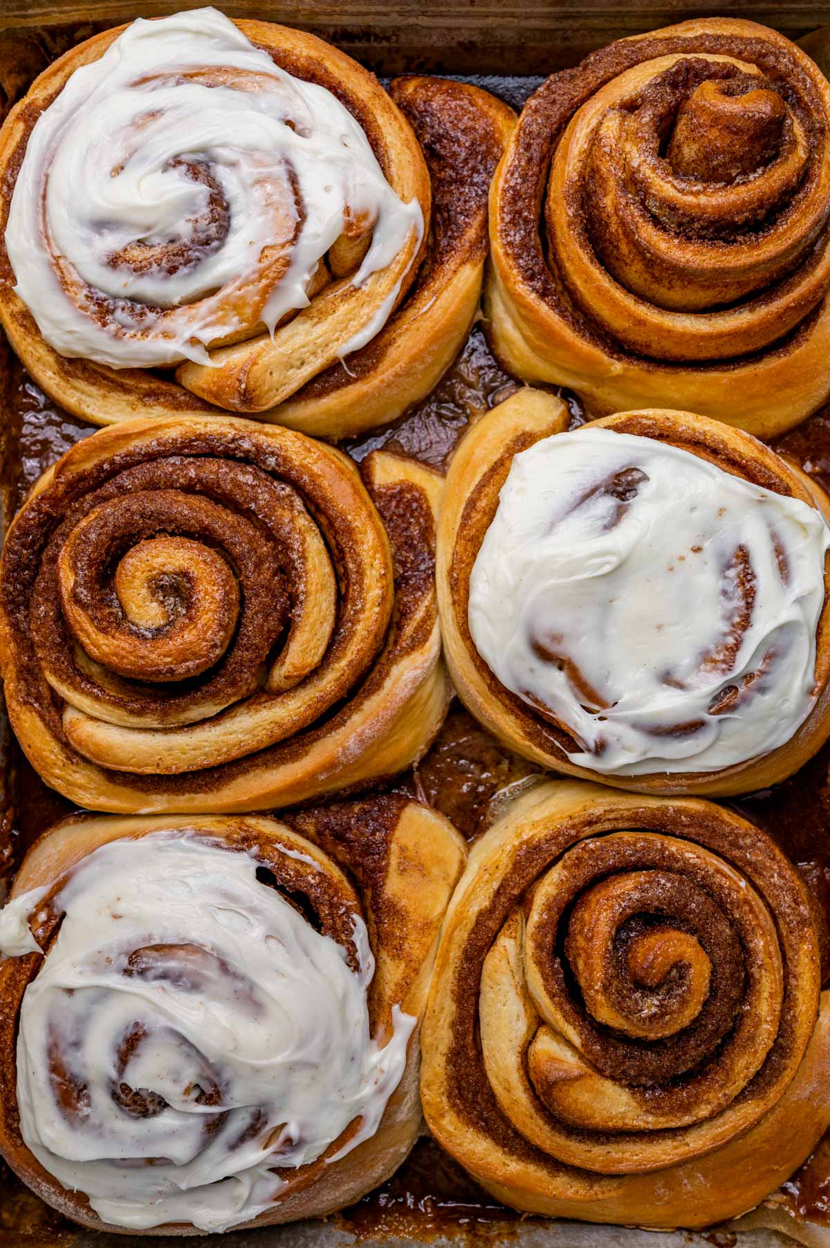 overhead view of giant cinnamon rolls with heavy cream