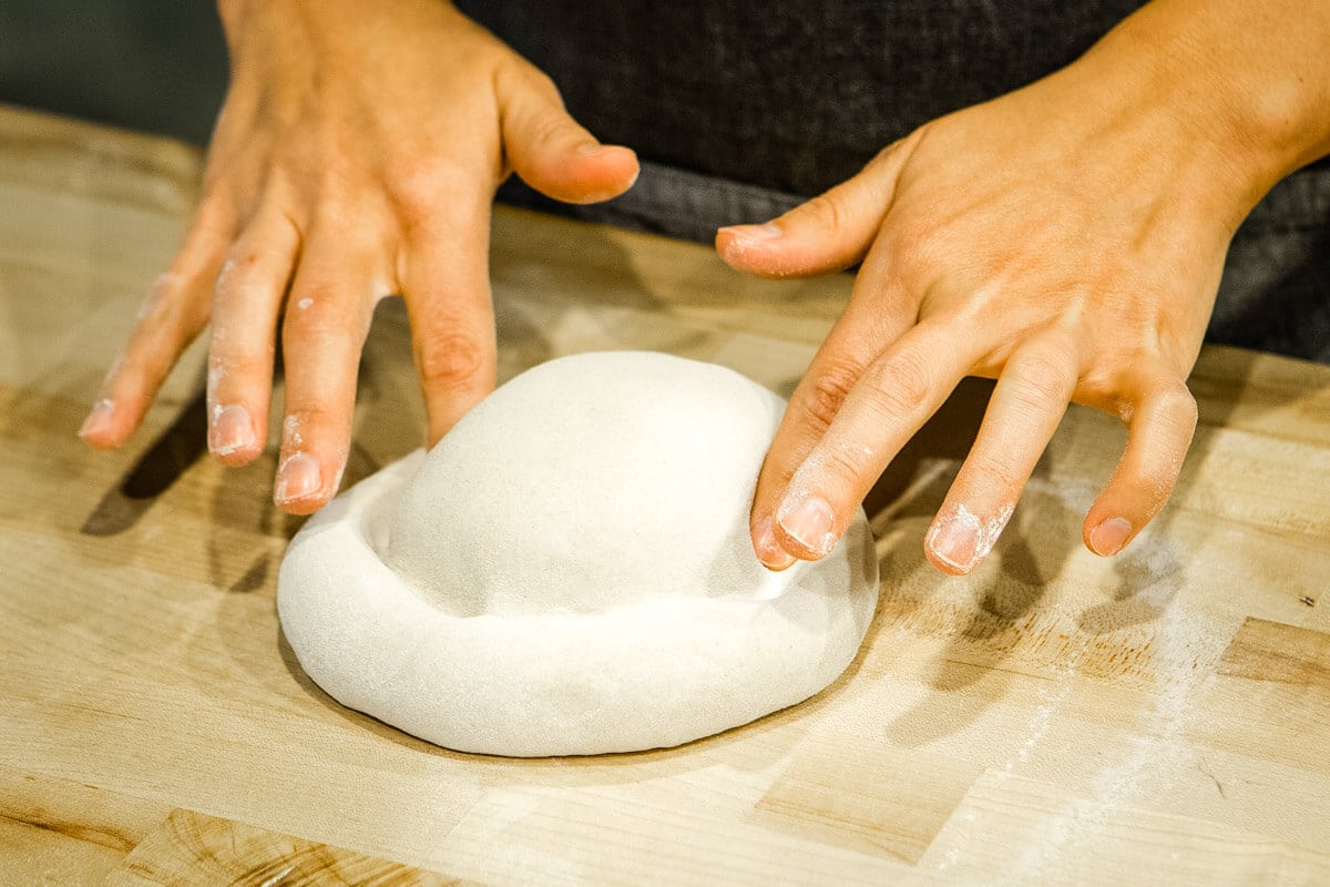 hands forming pizza dough