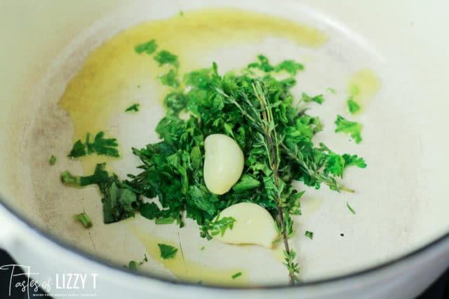 heating fresh herbs and garlic in a skillet