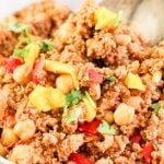 A close up of a bowl of food on a plate, with Picadillo