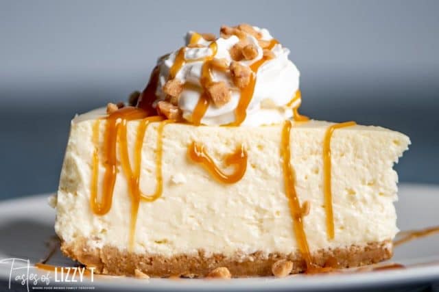 A close up of a slice of cheesecake and whip cream