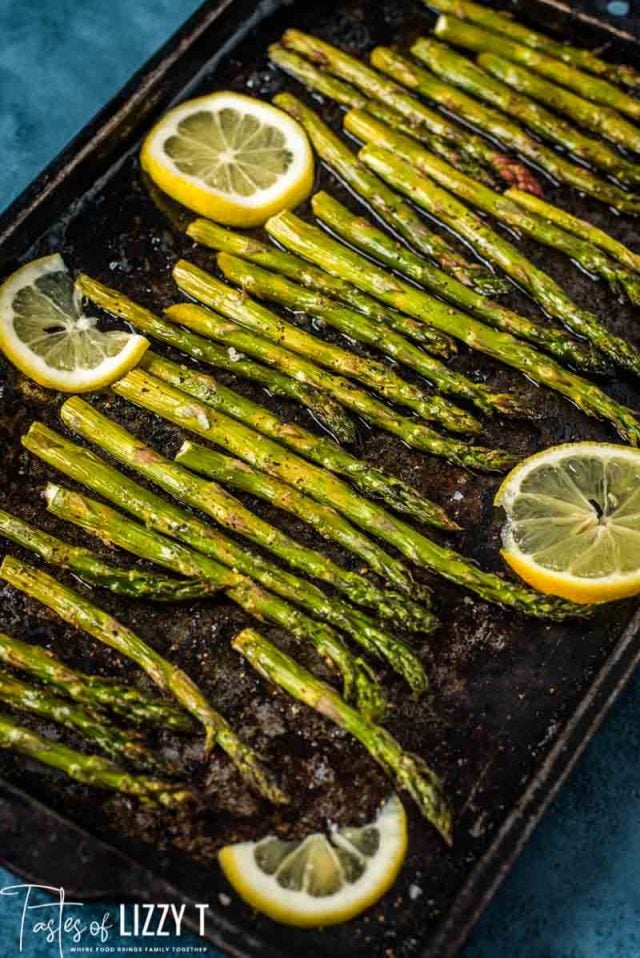 A close up of asparagus on a pan, with Lemon