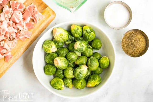 A plate of food on a table, with Bacon and Brussels sprout