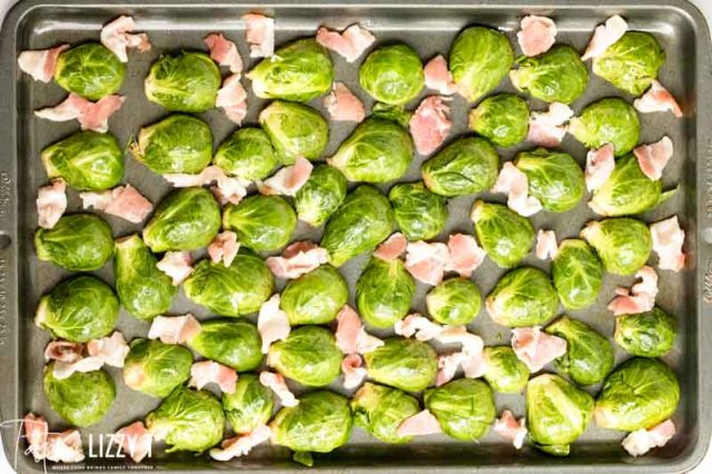 A bunch of food on a pan, with Bacon and Brussels sprout