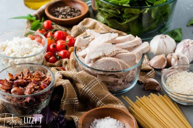 A table full of food, with Chicken and Pasta