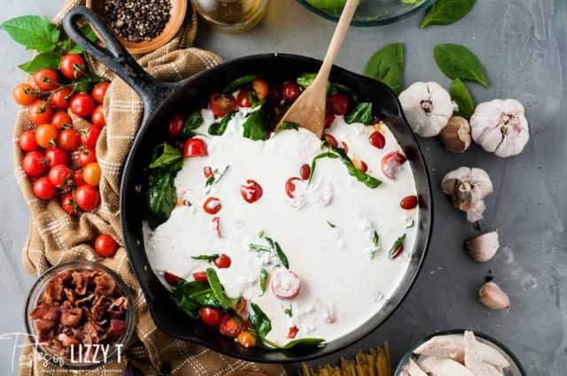 lettuce and tomatoes in a skillet with cream