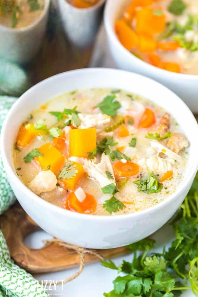 A bowl of food on a table, with Soup and Butternut squash