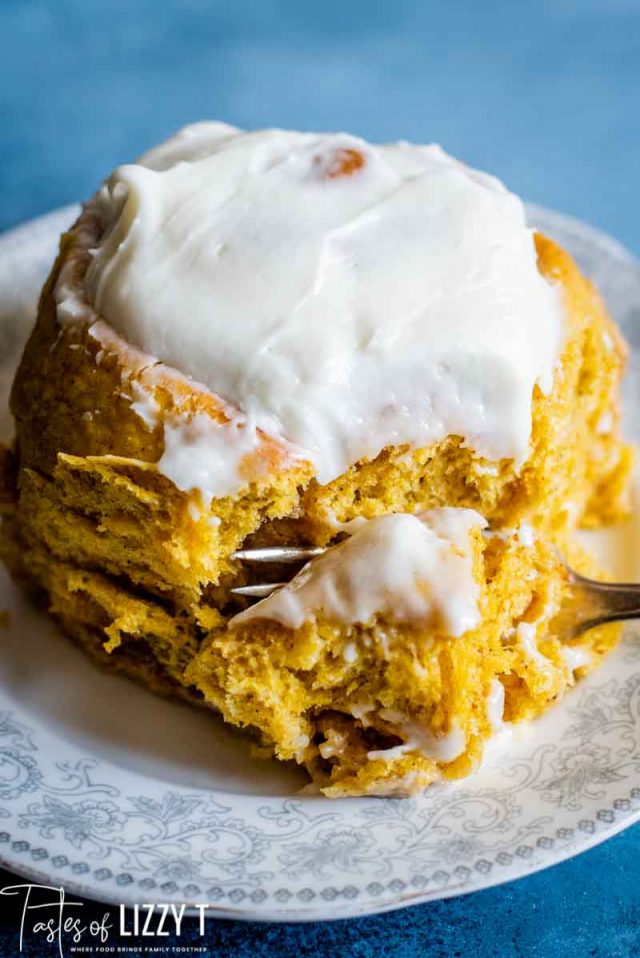 cinnamon roll on a plate with a fork