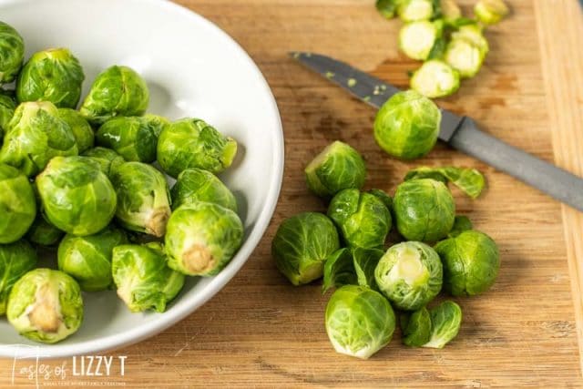 A plate of brussels sprouts on a wooden table