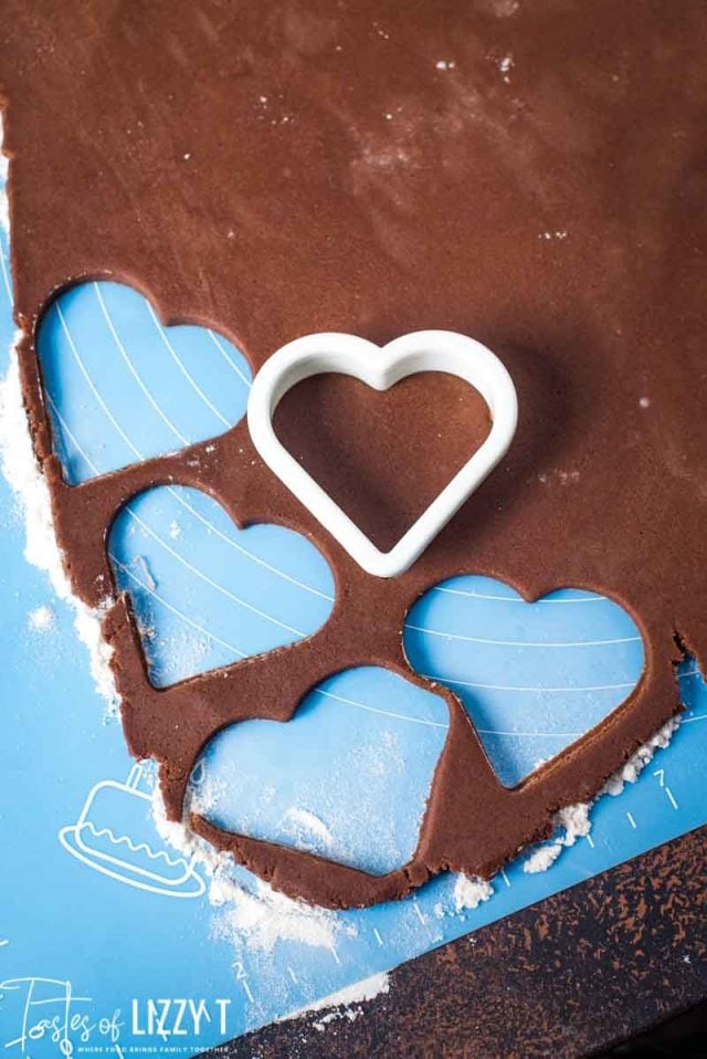 rolled out chocolate sugar cookie dough with heart cutouts